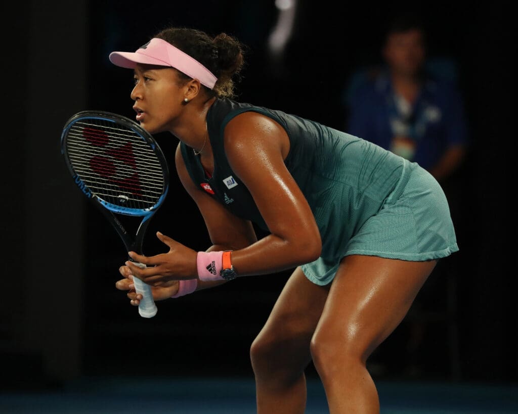A woman holding a tennis racket on the court
