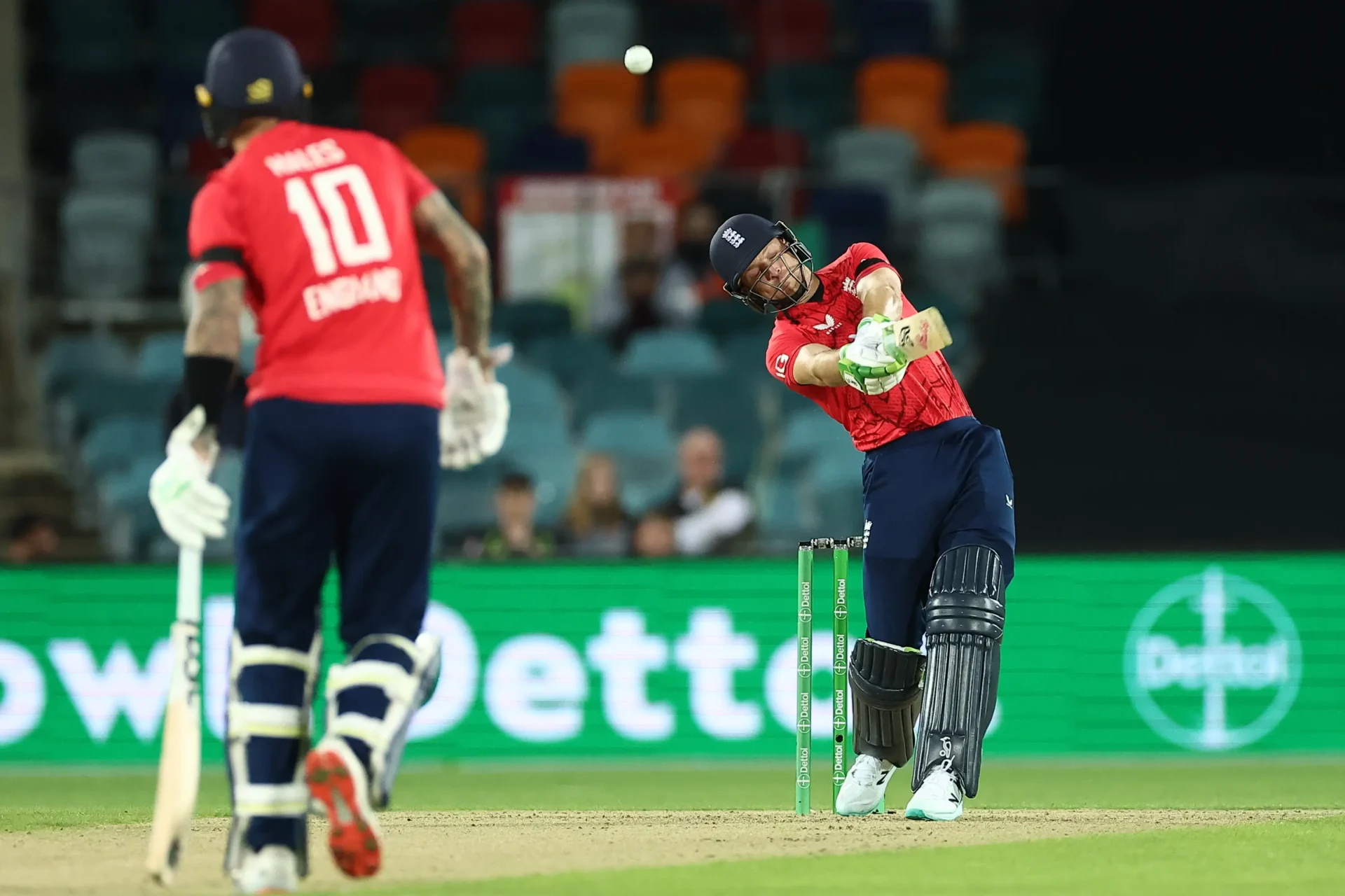 Batsman driving powerful cricket shot on field