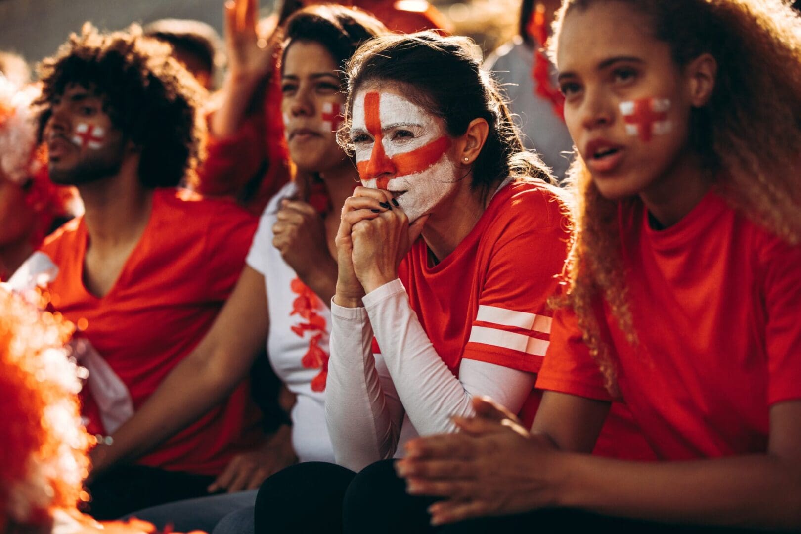 Fans with face paint watching sports game.