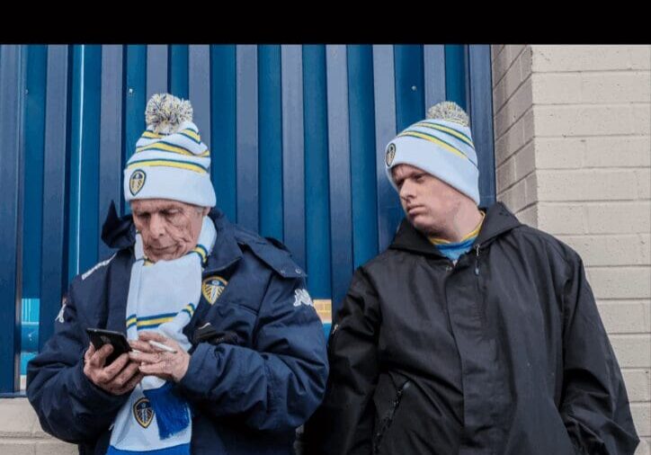 Two men in winter gear outside building.