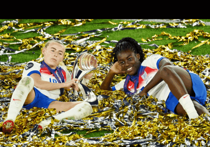 Soccer players celebrating with trophy on field.